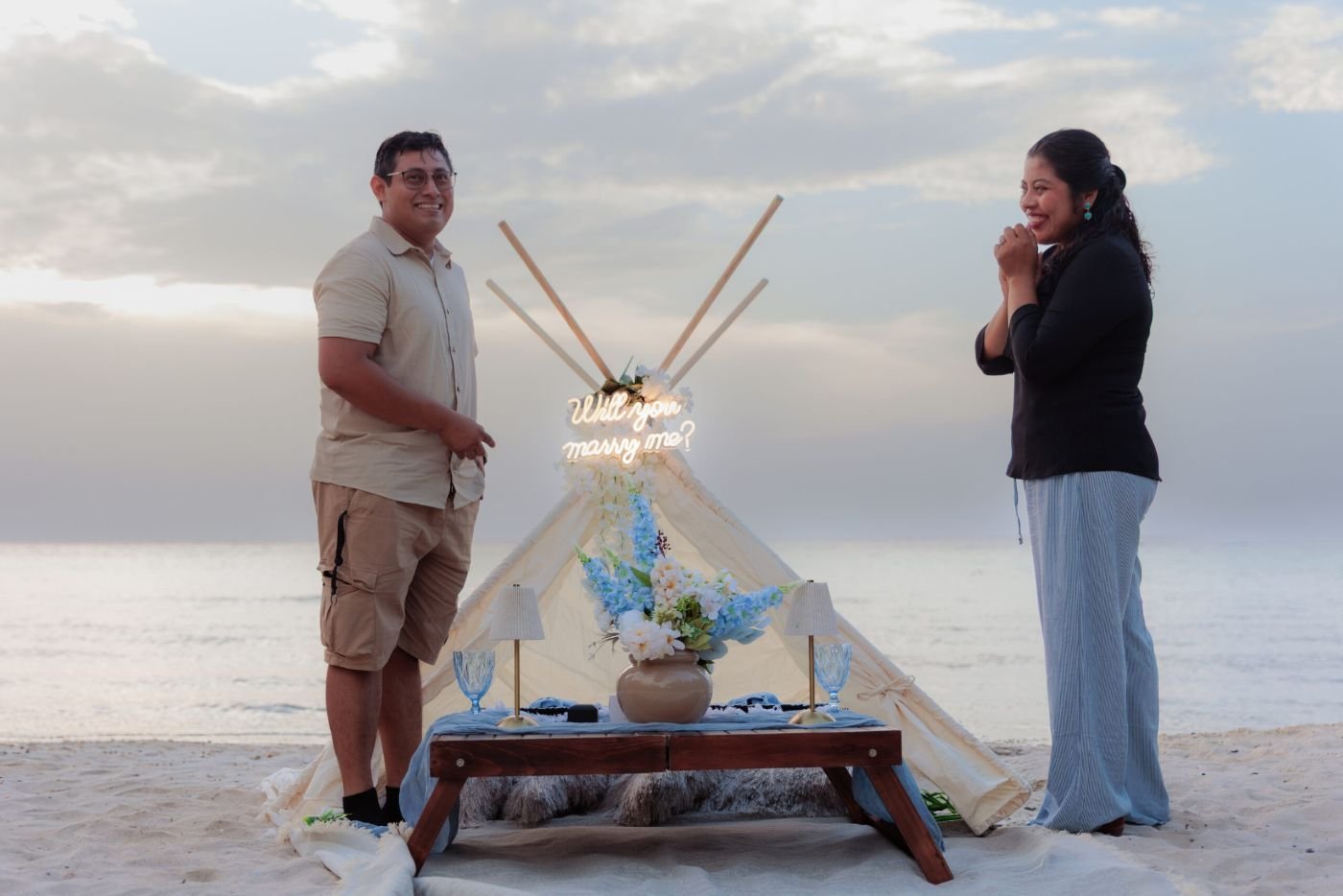 Boho teepee proposal setup on the beach at sunset