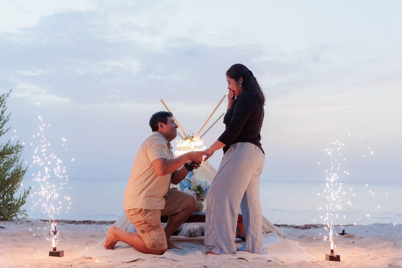 Couple toasting at their beach setup