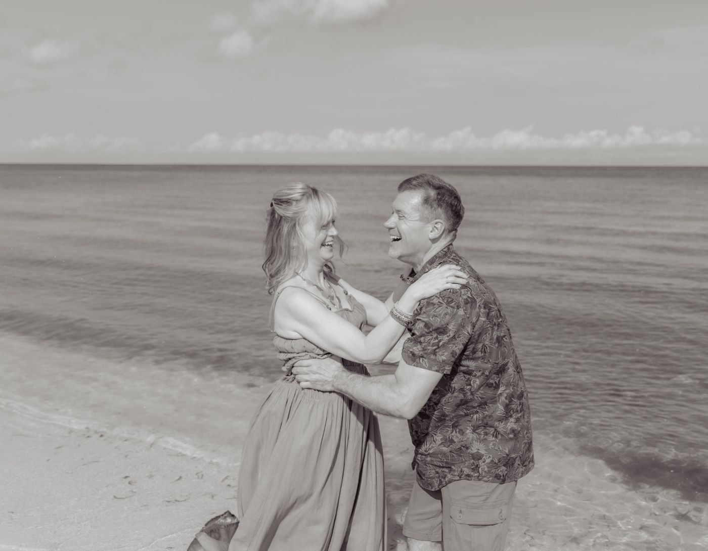 Couple embracing on the beach after the proposal