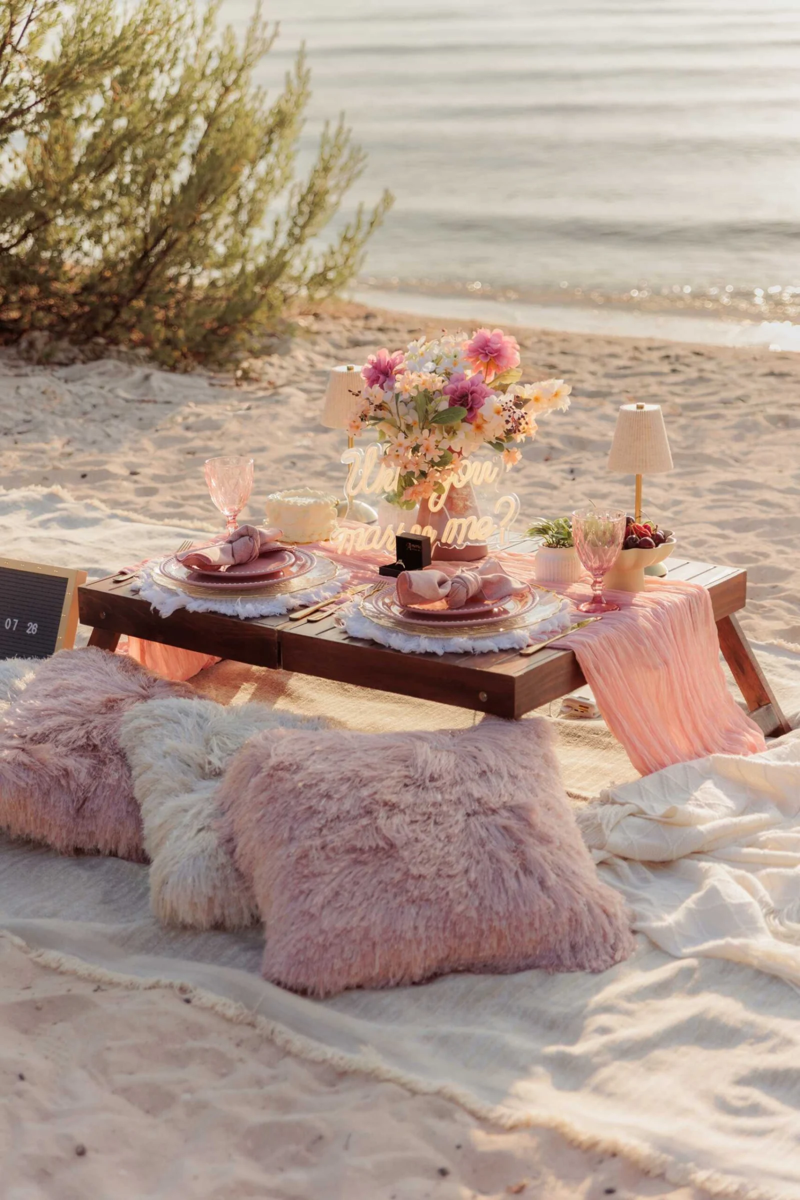 Pink-toned picnic set up on the beach in Cozumel at sunset