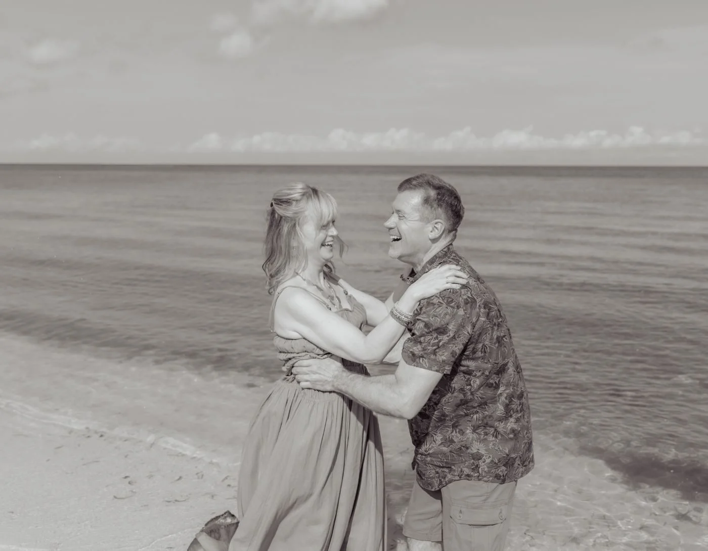 Couple embracing on the beach after the proposal