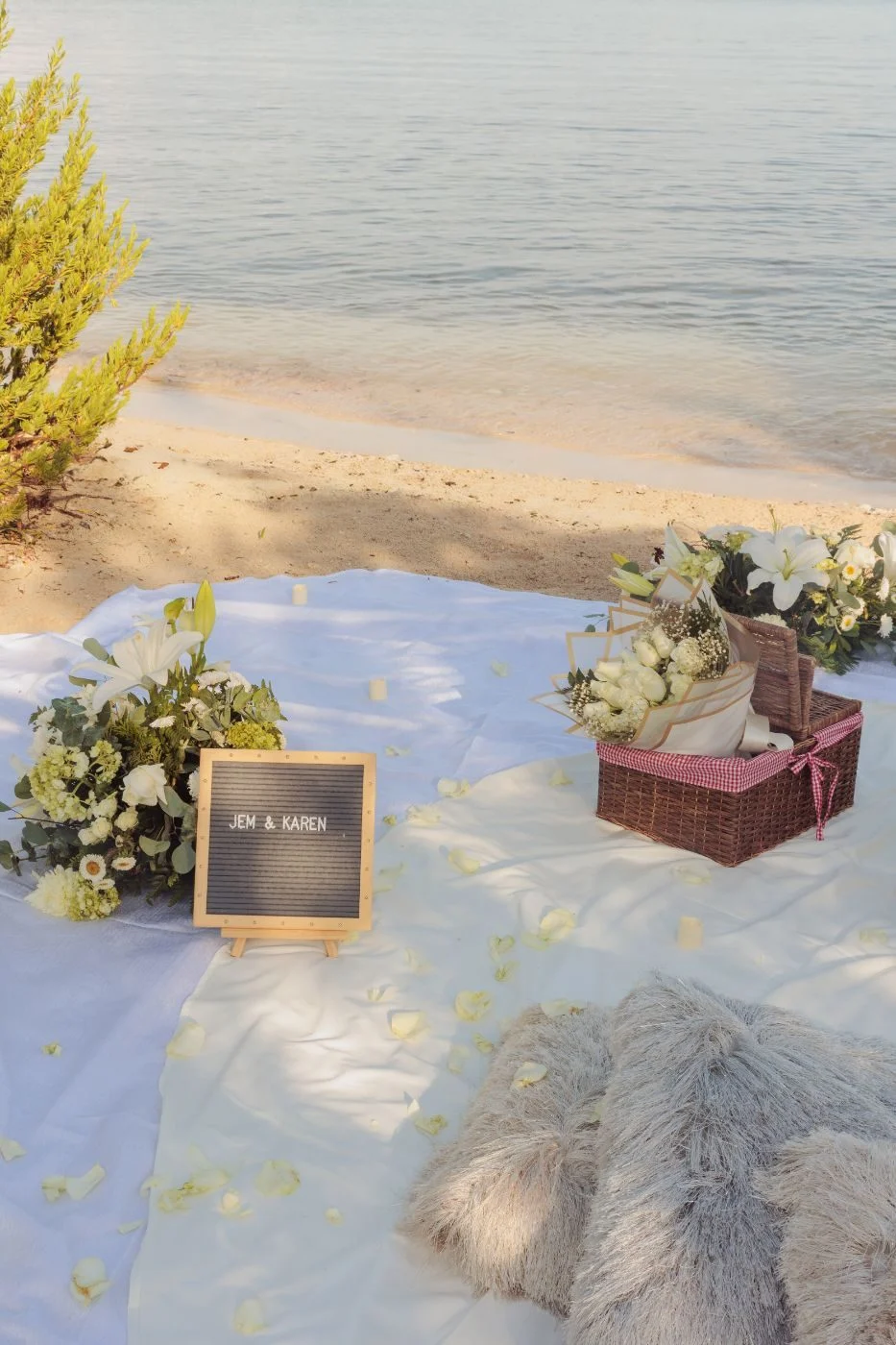 Wooden low table with white florals, fruit and champagne at sunset